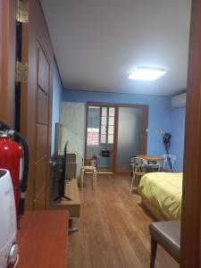 a bedroom with blue walls and a bed and a table at Solomon Room in Gwangju +3 photos