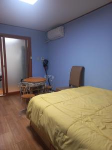 a bedroom with a bed and a table and chairs at Solomon Room in Gwangju