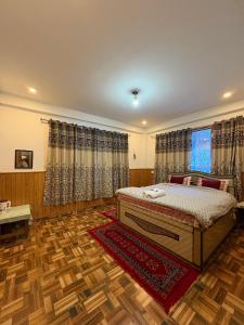 een slaapkamer met een bed en een houten vloer bij Alpine Lodge And Stays in Shangarh