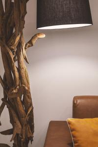 a lamp with a tree branch design next to a couch at Costa Rica Bibione SPA in Bibione