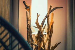 a vase filled with wooden branches in front of a window at Costa Rica Bibione SPA in Bibione