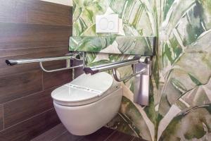 a bathroom with a toilet with two grab bars at Costa Rica Bibione SPA in Bibione