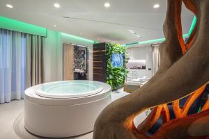 a wellness room with a tub in the middle of a tree at Costa Rica Bibione SPA in Bibione