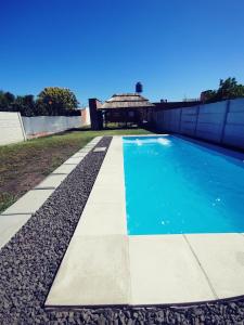Una piscina en un patio con un edificio. en Cabaña Las Martinetas, en María Grande