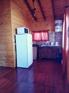 Cabaña con cocina con nevera blanca. en Cabaña Las Martinetas, en María Grande