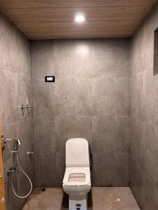 a bathroom with a toilet and a shower at Aartigamya Cottages Dandeli By StayApart in Dandeli