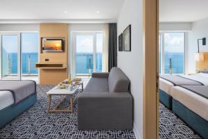 a hotel room with two beds and a couch at Royal Neptun Hotel in Dubrovnik