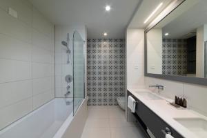 a white bathroom with a shower and a sink at Royal Neptun Hotel in Dubrovnik