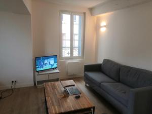 a living room with a couch and a coffee table at 2P refait à neuf, calme, quartier historique, entre seine et cathédrale in Mantes-la-Jolie