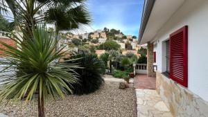 ein Haus mit einer Palme und einem roten Rollladen in der Unterkunft Villa Seaview in Santa Susanna