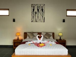 a bedroom with a bed with a swan on it at Villa Rosa East Bali in Karangasem