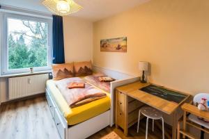 una piccola camera da letto con un letto e una scrivania di UFO´s Holiday Resort a Bad Reichenhall