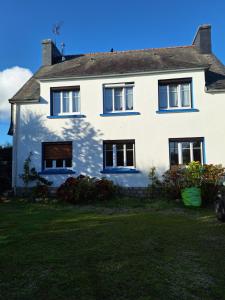 a white house with black windows and a yard at Nouelig bras in Loctudy
