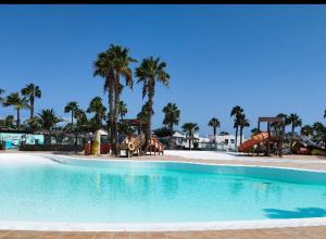 a large swimming pool with slides and a playground at Casa Camar in Corralejo