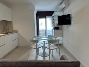 a kitchen and dining room with a table and chairs at Residence Bristol Bibione in Bibione