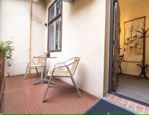 un patio con mesa y sillas junto a un edificio en Main Square Large Apartment, en Sibiu 10 fotos más