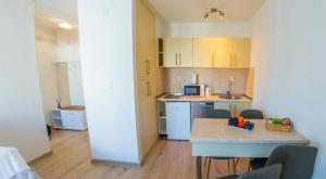 a small kitchen with a table and a microwave at Francis First in Mostar