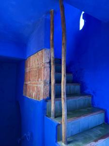 a staircase in a blue room with blue walls at Casa Amina in Chefchaouene