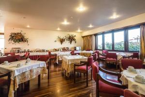 a dining room with tables and chairs and windows at Lam Hotel Fortaleza de Almeida in Almeida