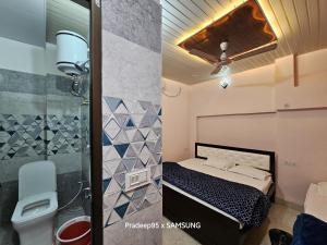 una piccola camera da letto con un letto e una doccia di Shri Mahaveer Residency a Ayodhya