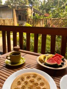 a table with two plates of fruit and a cup of coffee at Coffee Homestay Tetebatu in Tetebatu +27 photos
