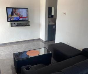 a living room with a couch and a flat screen tv at Exclusive-View Lodge in Akropong