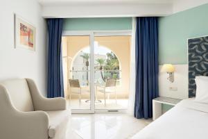 a bedroom with a bed and a table and chairs at Iberostar Selection Diar El Andalous in Port El Kantaoui