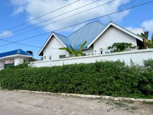 a white house with a blue roof at Upendo Villa kewengwa in Kiwangwa