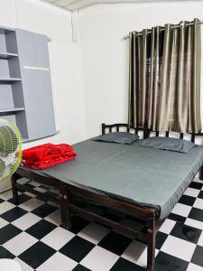 a bed sitting in a room with a fan at GreenSpot Homestay in Idukki
