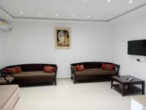a living room with two couches and a flat screen tv at Studio LINA in Hennchir Ksar Rhaleb