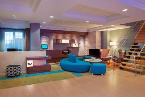 a lobby with blue chairs and tables and stairs at Fairfield Inn & Suites by Marriott Ottawa Kanata in Ottawa