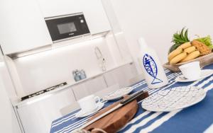 a kitchen with a table with a bowl of bananas and a bottle of milk at Costa Rica Bibione Eco Resort in Bibione