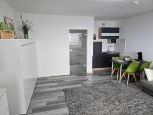 a living room with a table and a kitchen at 1 Zimmer Wohnung Laatzen nähe Messe in Hannover +3 photos