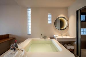 ein Badezimmer mit großer Badewanne und Waschbecken in der Unterkunft The ShanUU Hotel in Dali + 201 Fotos