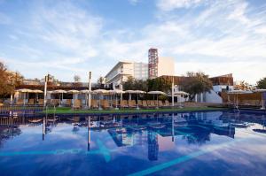 a large swimming pool with chairs and umbrellas at Hotel Puchet Ibiza in San Antonio