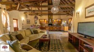 a living room with a couch and a flat screen tv at Zebula Golf and Wildlife Estate - Moi Signature Exclusive Leisure Villas in Mabula