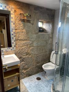 a bathroom with a toilet and a sink and a shower at A casiña do abuelo Pepe in A Lama +8 photos