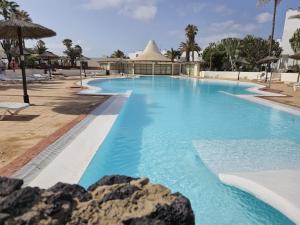 a pool at a resort with blue water at Villa Las Marias Suite - Playa Roca Residence in Costa Teguise