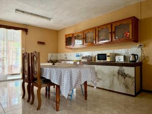 a kitchen with a table with chairs and a counter at Transit Home - 10 mins from airport & Blue Bay Beach in Mare dʼAlbert +5 photos