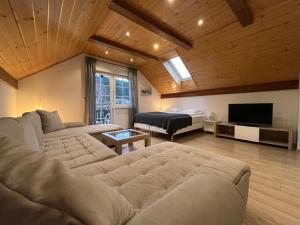 a living room with a large couch and a bedroom at Beskid Bukowa in Szczyrk