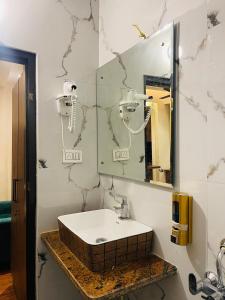 a bathroom with a sink and a mirror at The Taaj Comforts in Bengaluru