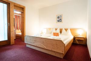 マルタにあるPirker's Natur- & Bio Familienhotelのベッドルーム1室(大型木製ベッド1台付) +38枚の写真