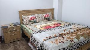 a bedroom with a bed and a dresser with a bed sidx sidx at Paradise Lodges Muzaffarabad in Muzaffarabad