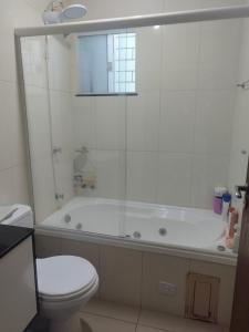a bathroom with a toilet and a bath tub with a shower at Casa Central Super Conforto 78 in Ponta Grossa