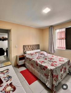 a bedroom with a large bed with a red blanket at apto frente praia pé na areia 2dorm wifi elevador Smart tv praia grande aviação - leia fotos in Praia Grande