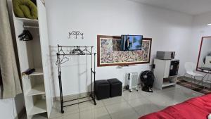 a room with a bed and a tv on the wall at Apto Girassol in Monte Verde