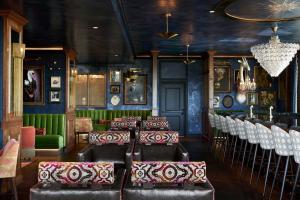 a bar with chairs and tables in a room at The Memphian a Tribute Portfolio Hotel in Memphis