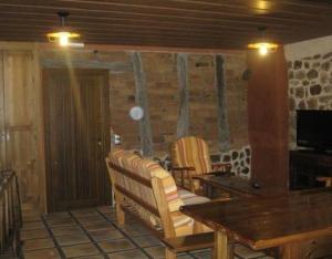 a living room with a wooden table and chairs at La Botería in Salas de los Infantes