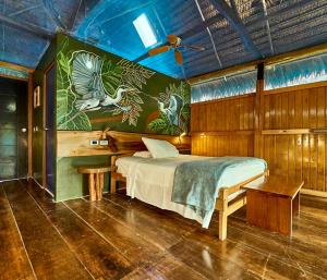a bedroom with a bed with a painting on the wall at Amazon Muyuna Lodge - All Inclusive in Paraíso