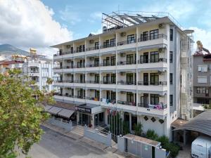 an image of a white building with balconies at Kandelor Hotel in Alanya